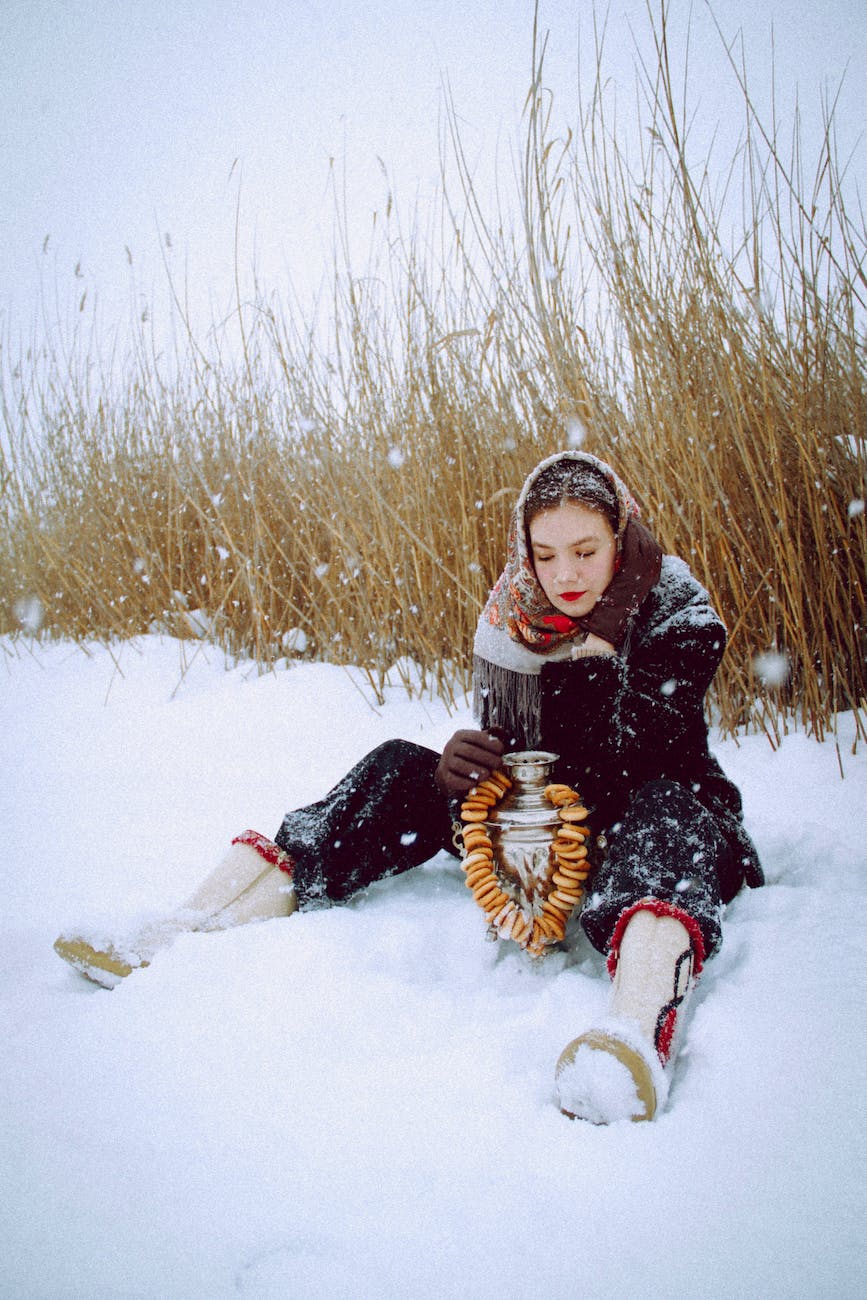 woman holding an urn sitting on snow