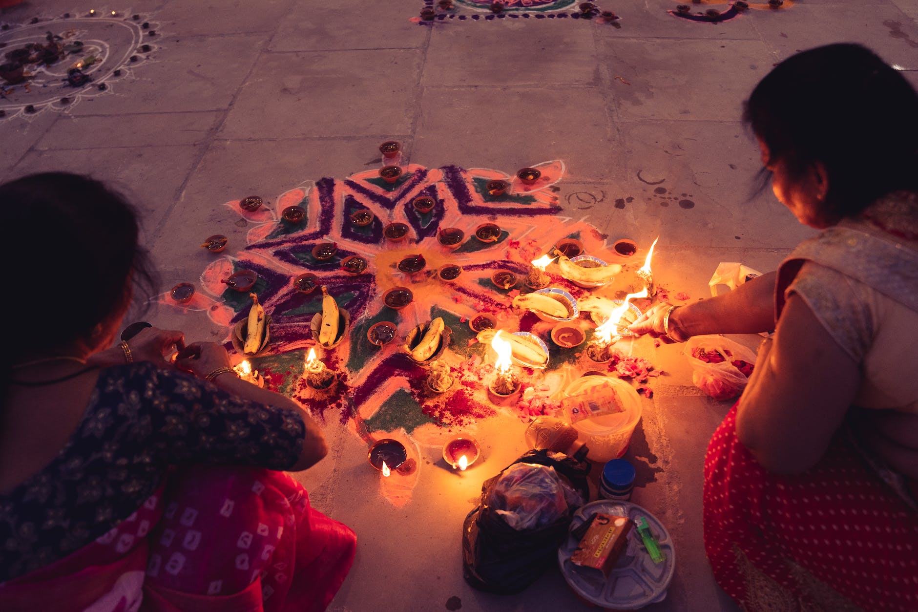 women in saree burning candles at a traditional festivity