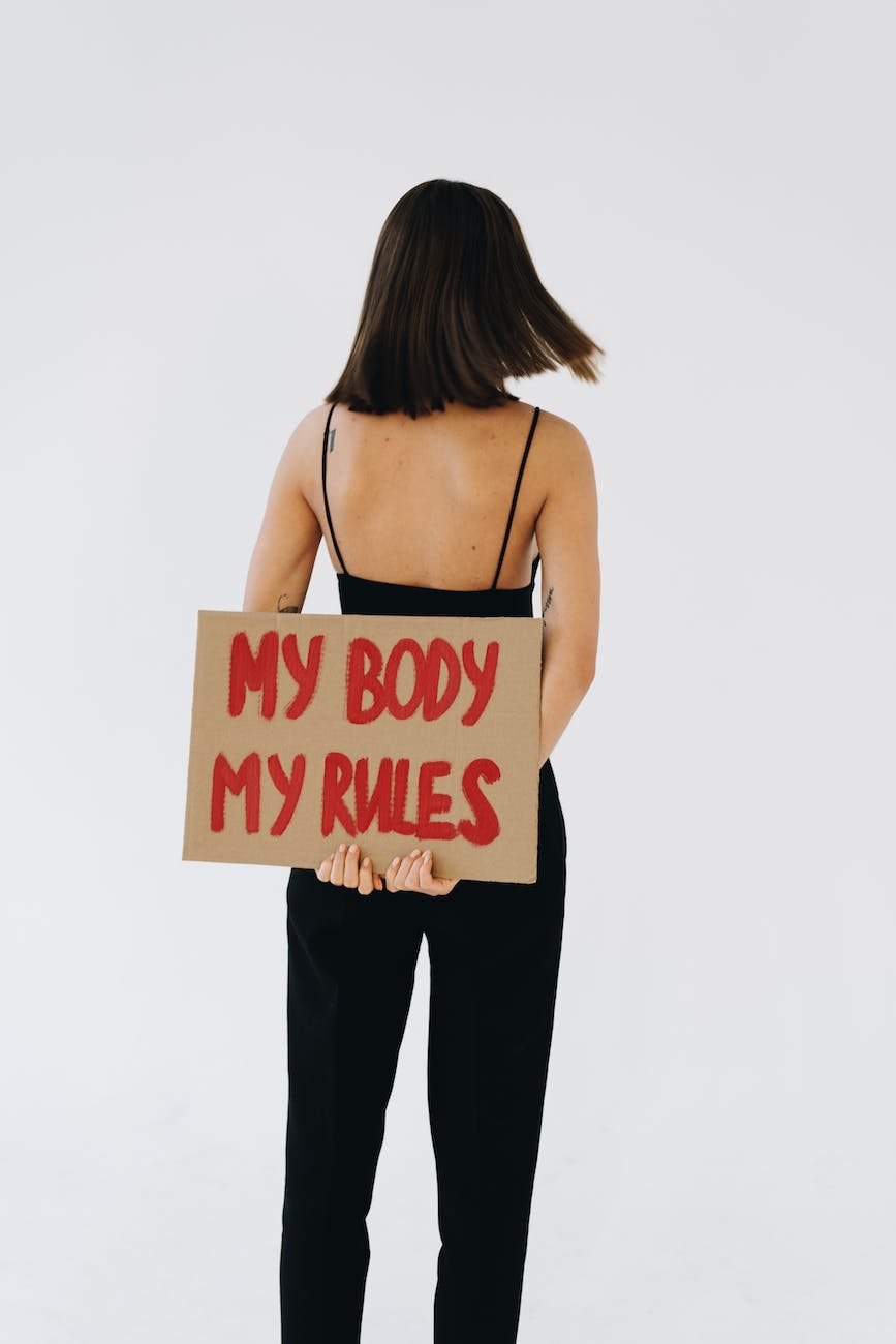back view of a woman holding a placard about my body my rules